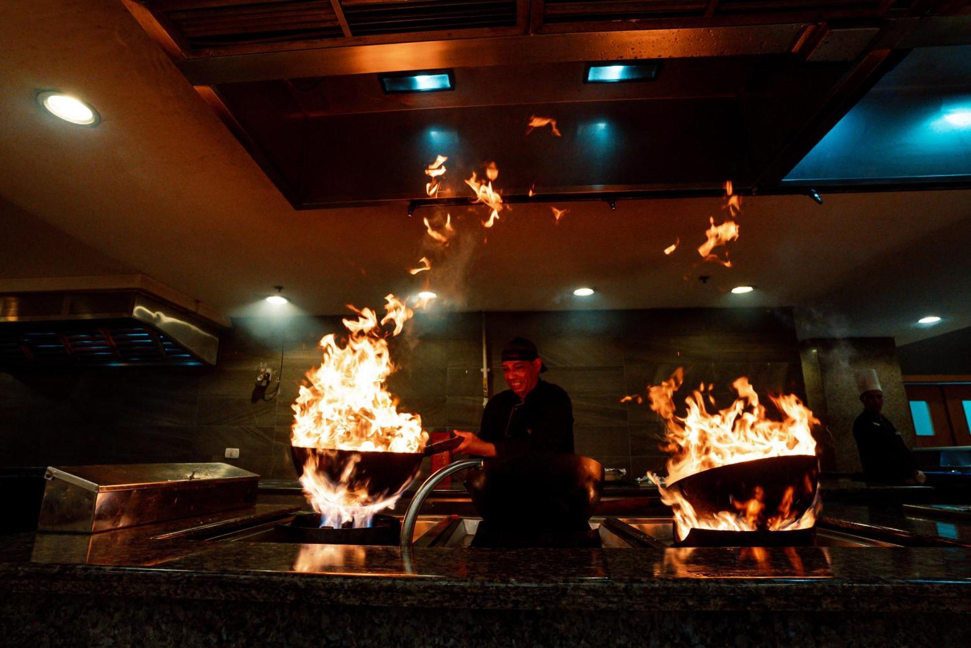 The V Luxury Resort Sahl Hasheesh Hurghada Exteriör bild A chef cooking with a wok