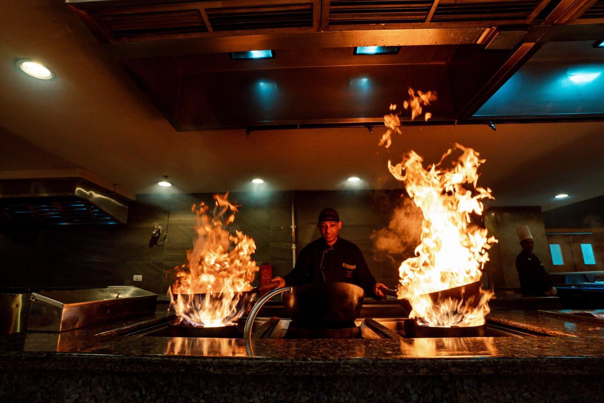 The V Luxury Resort Sahl Hasheesh Hurghada Exteriör bild A chef cooking with a wok
